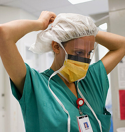 Krankenschwester mit Mundschutz und OP-Haube