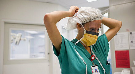 Krankenschwester mit Mundschutz und OP-Haube