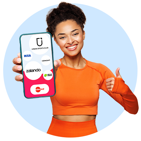 Lächelnde Frau in orangefarbener Sportkleidung hält ein Smartphone auf dessen Display Logos wie Urban Sports Club, IKEA, Zalando, Cyberport und HelloFresh zu sehen sind; sie zeigt mit der freien Hand einen Daumen nach oben vor hellblauem Hintergrund.