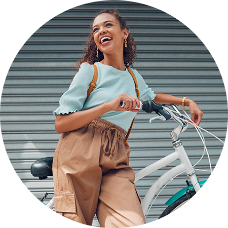 Frau steht lächelnd an ihr Fahrrad gelehnt