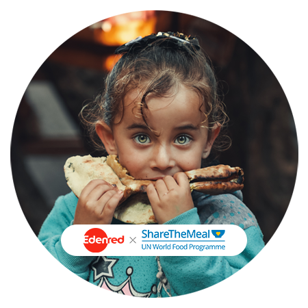 Mädchen mit lockigem Haar und grünen Augen beißt in ein Fladenbrot; am unteren Bildrand die Logos „Edenred“ und „ShareTheMeal – UN World Food Programme“